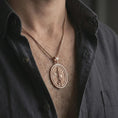 Load image into Gallery viewer, Rose gold plated Saint Michael spinning pendant necklace worn on the chest, close-up lifestyle shot featuring the sacred archangel protection design with warm rose gold tones.
