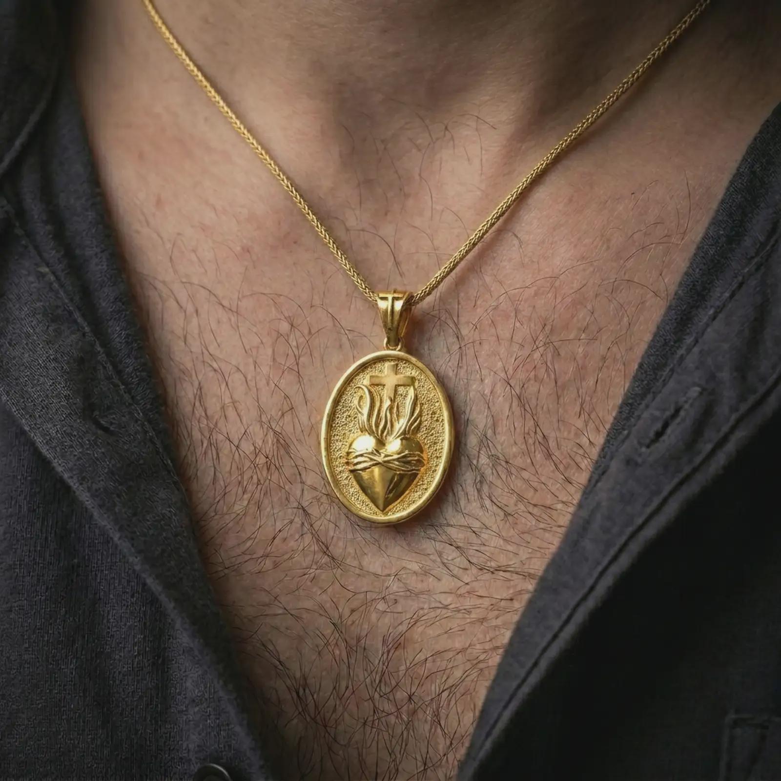 Gold plated Sacred Heart pendant necklace worn on the chest, premium lifestyle jewelry photo with the Sacred Heart medal centered on a spiga chain.
