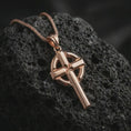 Load image into Gallery viewer, Rose gold plated Celtic cross pendant necklace on porous black volcanic rock, featured in a luxury macro image with a timeless Christian symbol and distinct circular frame behind the cross.
