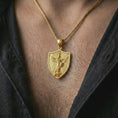 Load image into Gallery viewer, Gold plated Saint Michael pendant necklace worn on the neck, captured in a premium lifestyle composition that highlights the warrior angel motif as a meaningful Christian statement piece.
