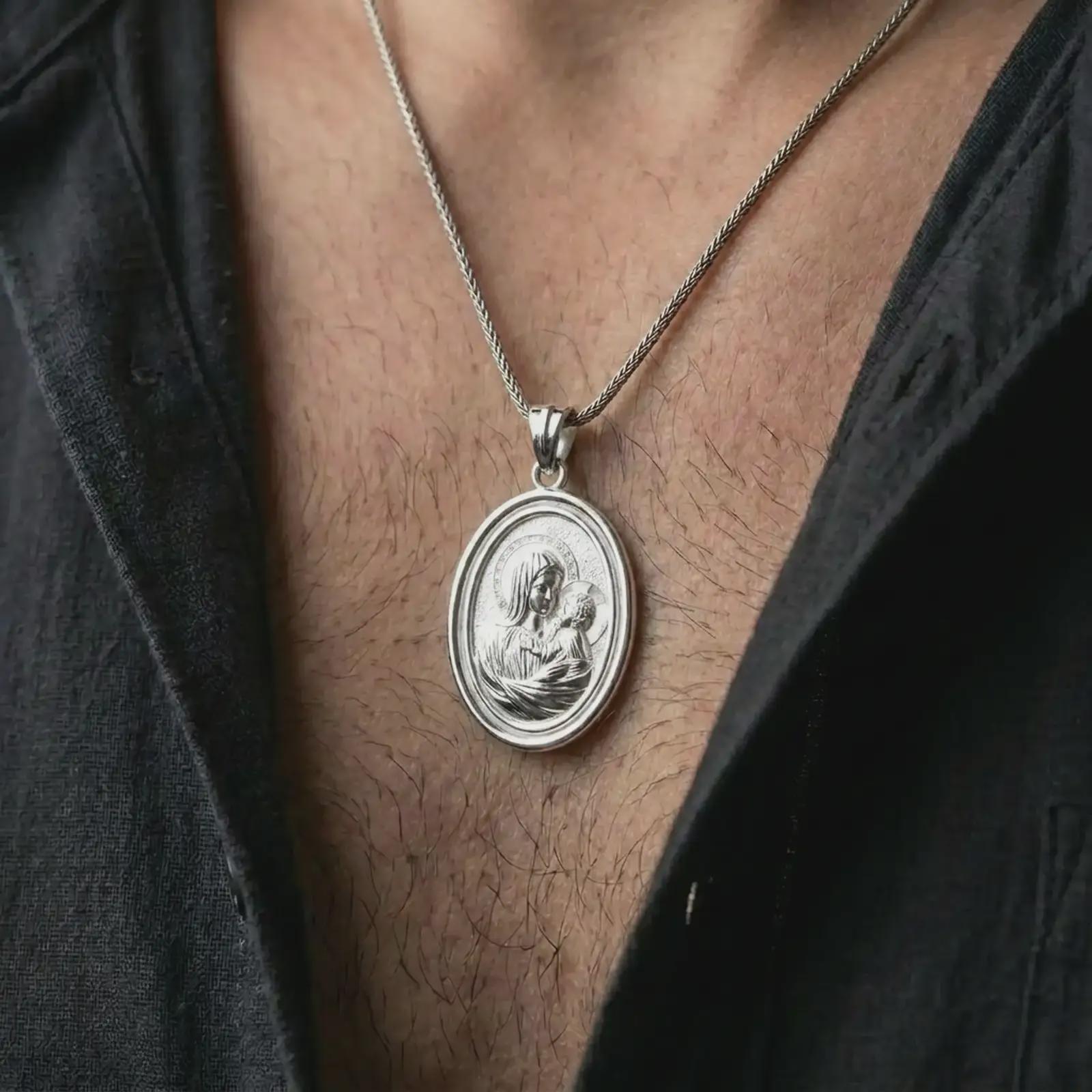 Polished silver Madonna and Child pendant necklace worn on the neck, shown in a clean model shot with the Virgin Mary and baby Jesus pendant centered for a timeless devotional look.