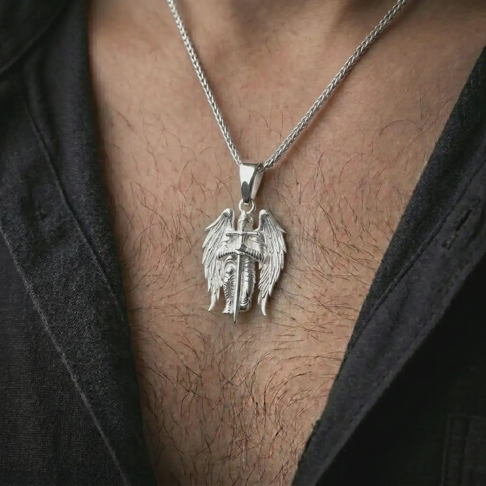 Polished silver angel warrior pendant necklace worn on the neck, shown in a refined model shot with the detailed guardian angel and sword pendant centered for a bold devotional look.