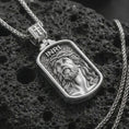 Load image into Gallery viewer, Polished silver INRI Jesus pendant necklace on textured volcanic rock, centered macro jewelry photo with detailed Christian portrait relief and bright silver highlights.
