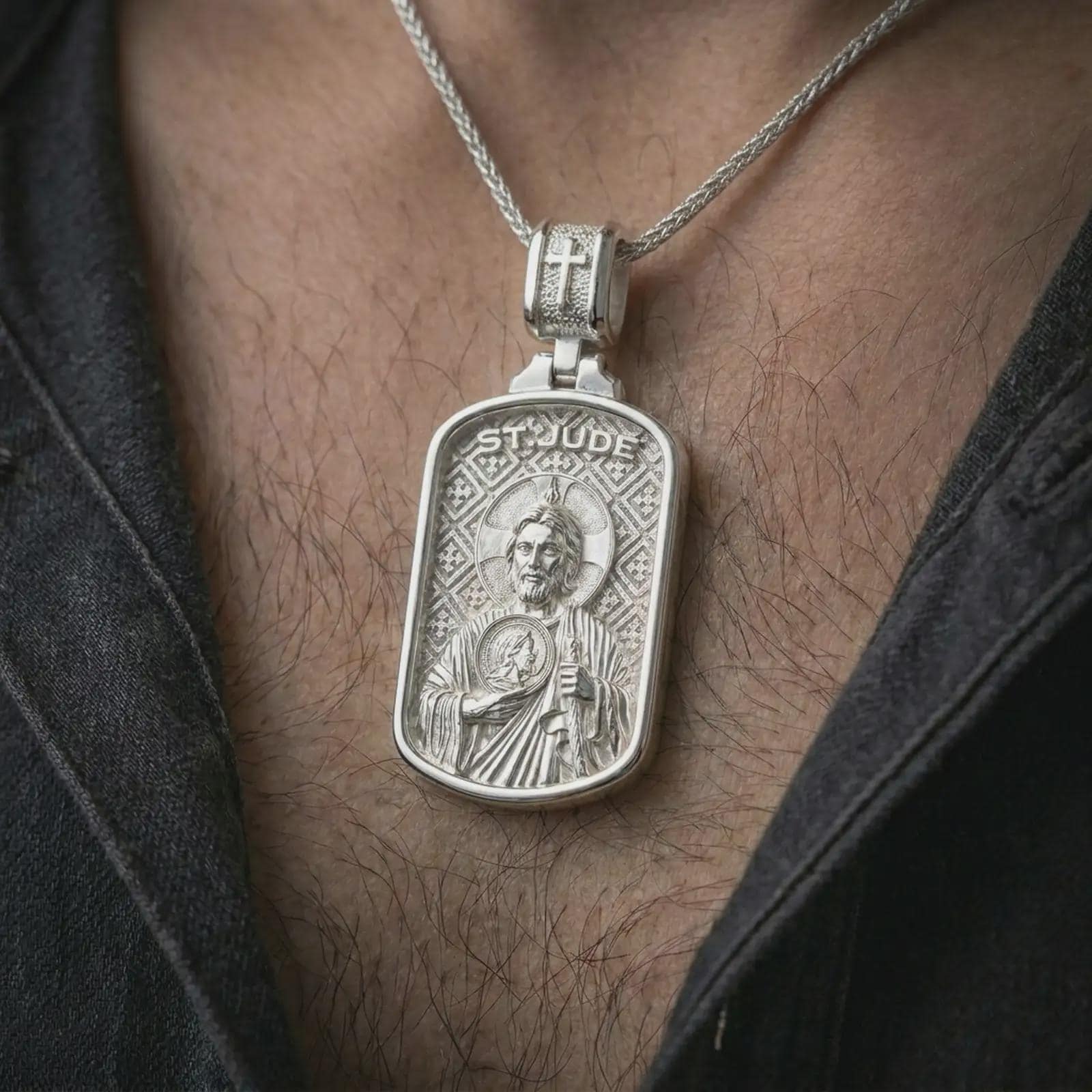 Polished silver Saint Jude dog tag pendant necklace worn on the chest, masculine lifestyle shot highlighting the saint relief, halo, medallion detail, and bright silver finish.