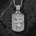 Load image into Gallery viewer, Polished silver Saint Dominic dog tag pendant necklace on textured volcanic rock, centered macro jewelry photo with detailed religious medal engraving and bright silver highlights.

