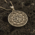 Load image into Gallery viewer, Bronze Manipura chakra pendant necklace on textured volcanic rock, close-up studio shot highlighting the solar plexus symbol, lotus petals, geometric center, and antique silver contrast.
