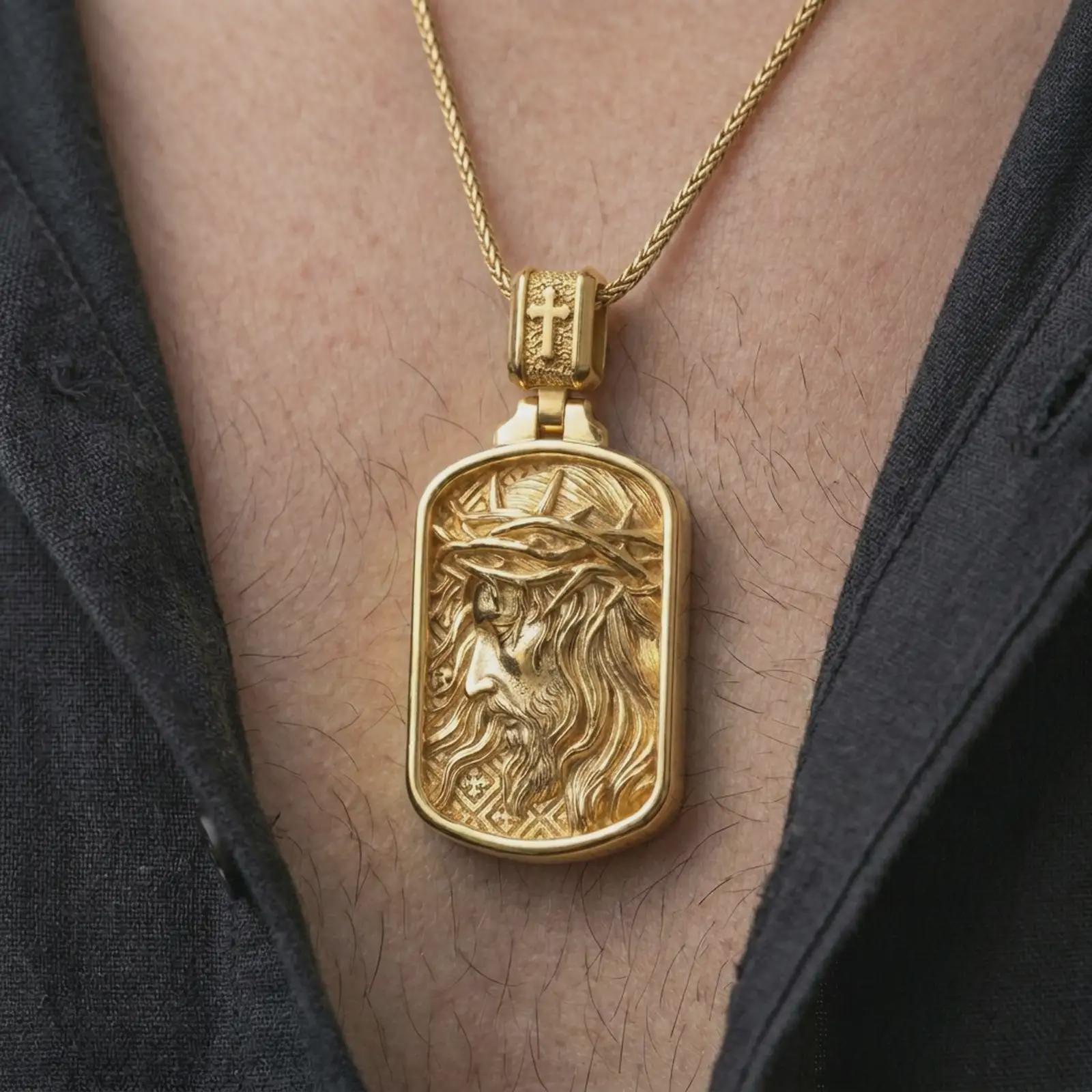 Gold plated crucified Jesus dog tag pendant necklace worn on the chest, premium lifestyle jewelry photo with the crucified Jesus portrait medal centered on a spiga chain.