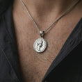 Load image into Gallery viewer, Polished silver Tiberius coin pendant necklace worn on the neck, shown in a clean model shot with the classical Roman coin pendant centered for a refined heritage-inspired look.
