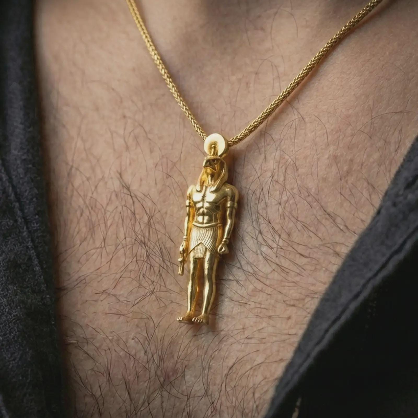 Gold plated Ra amulet pendant necklace worn on the neck, captured in a premium lifestyle composition that highlights the sun god motif as a distinctive heritage jewelry accent.