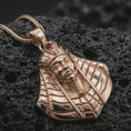 Load image into Gallery viewer, Rose gold plated Tutankhamun pendant necklace presented on textured volcanic stone, showcasing the pharaoh portrait, regal headdress, and refined antiquity-inspired design in a macro studio shot.
