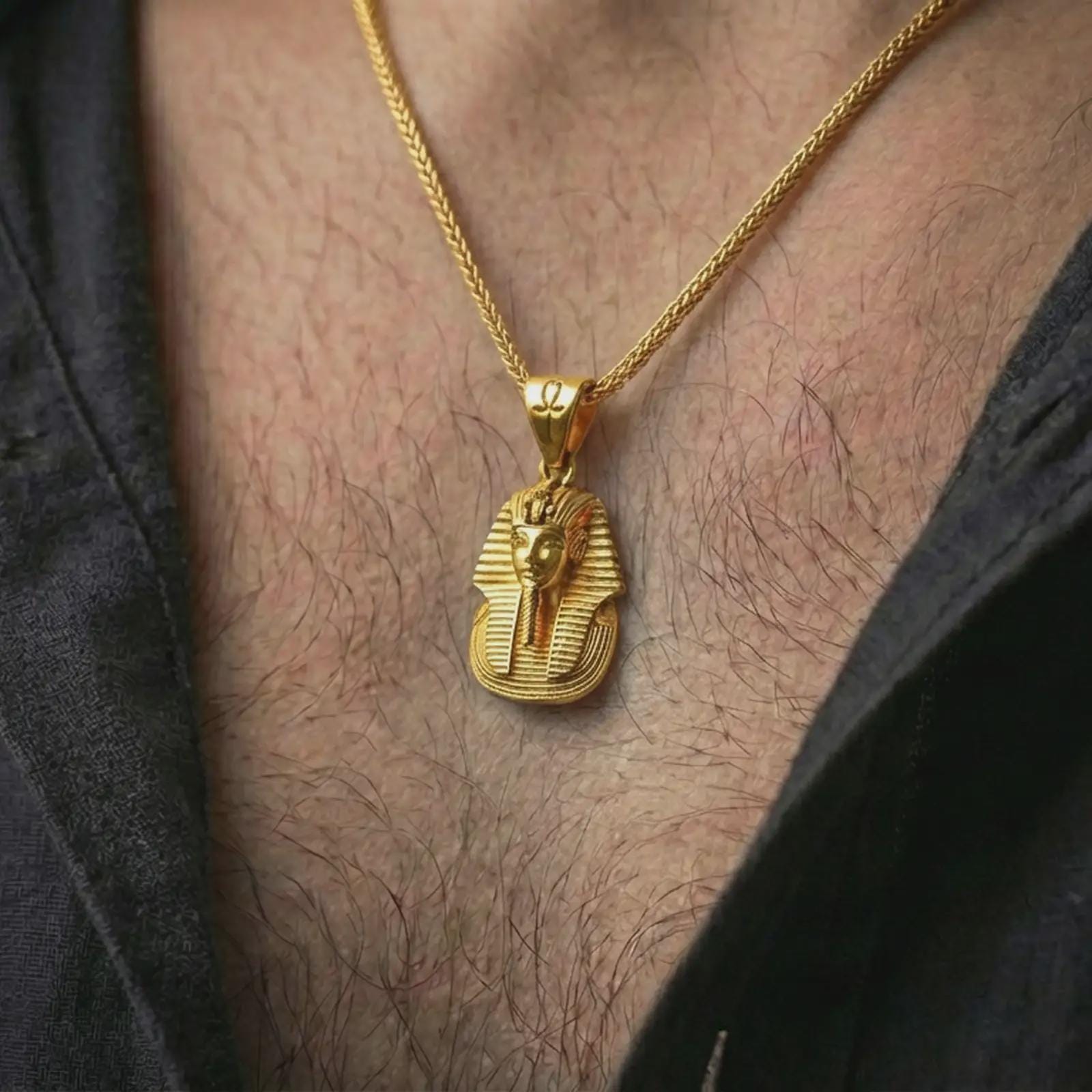 Gold plated Tutankhamun pharaoh pendant necklace worn on the neck, captured in a premium lifestyle composition that highlights the royal pharaoh motif as a distinctive heritage jewelry accent.