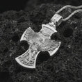 Load image into Gallery viewer, Polished silver Saint Michael cross pendant necklace on textured volcanic rock, centered macro jewelry photo with detailed archangel relief and bright silver highlights.
