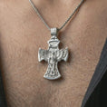 Load image into Gallery viewer, Polished silver Saint Michael cross pendant necklace worn on the chest, masculine lifestyle shot highlighting the angel wings, sword detail, and bright silver finish.
