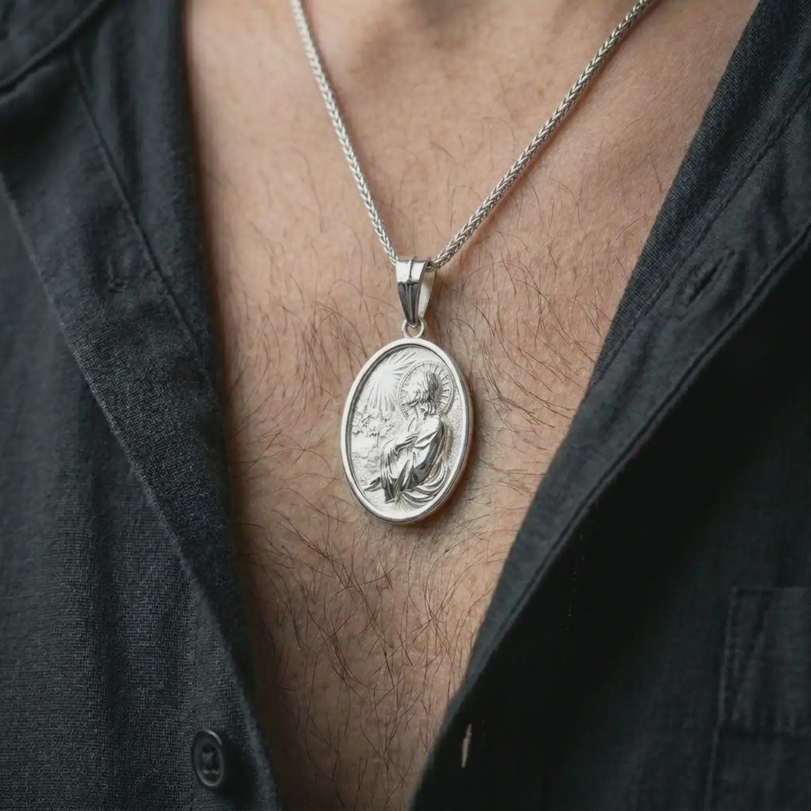 Polished silver Jesus Christ prayer pendant necklace worn on the chest, masculine lifestyle shot highlighting the praying Christ relief, halo, and bright silver finish.