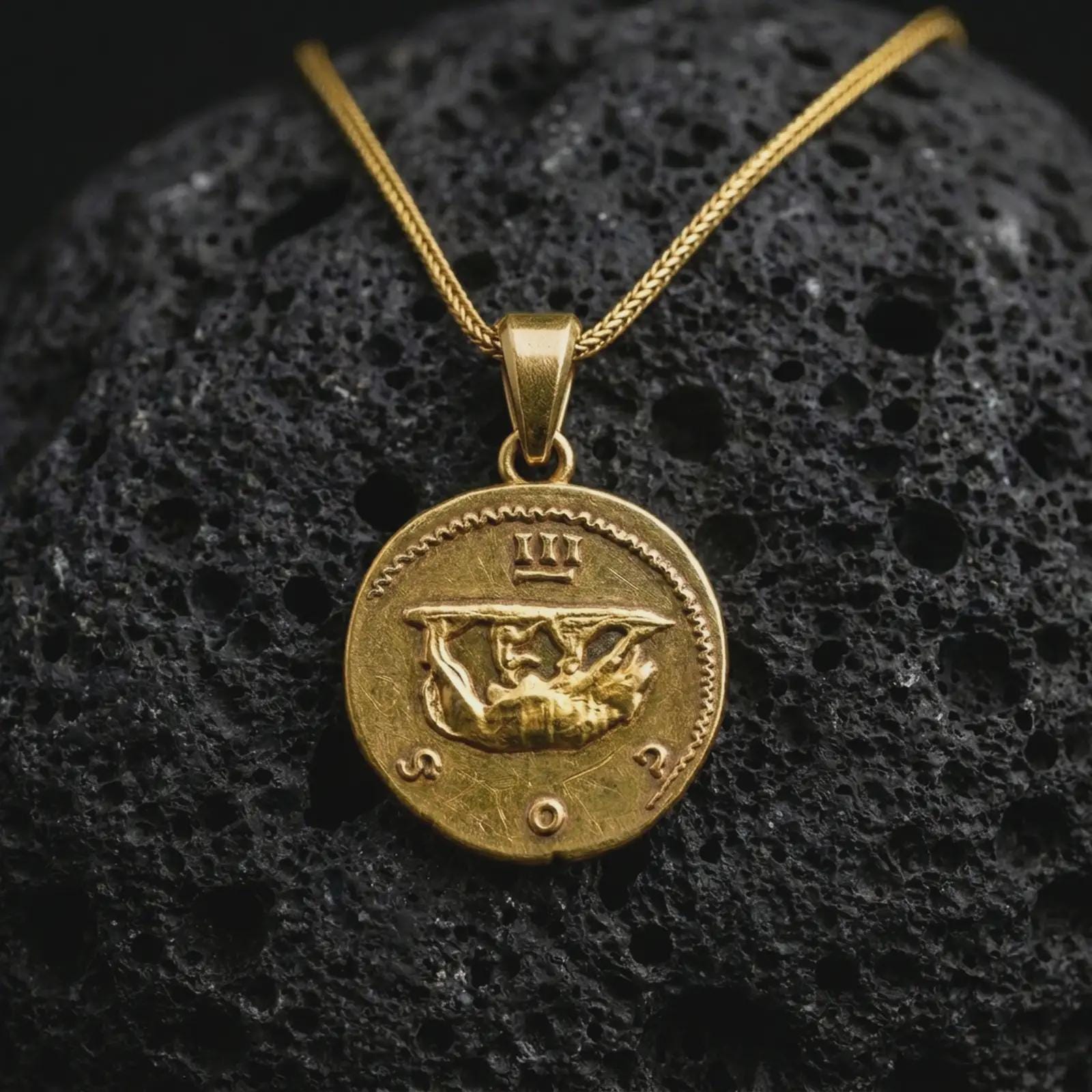 Gold plated Emperor Augustus coin pendant necklace photographed on porous black volcanic stone, emphasizing the imperial bust, laurel crown, and historical Latin inscription in a luxury jewelry composition.