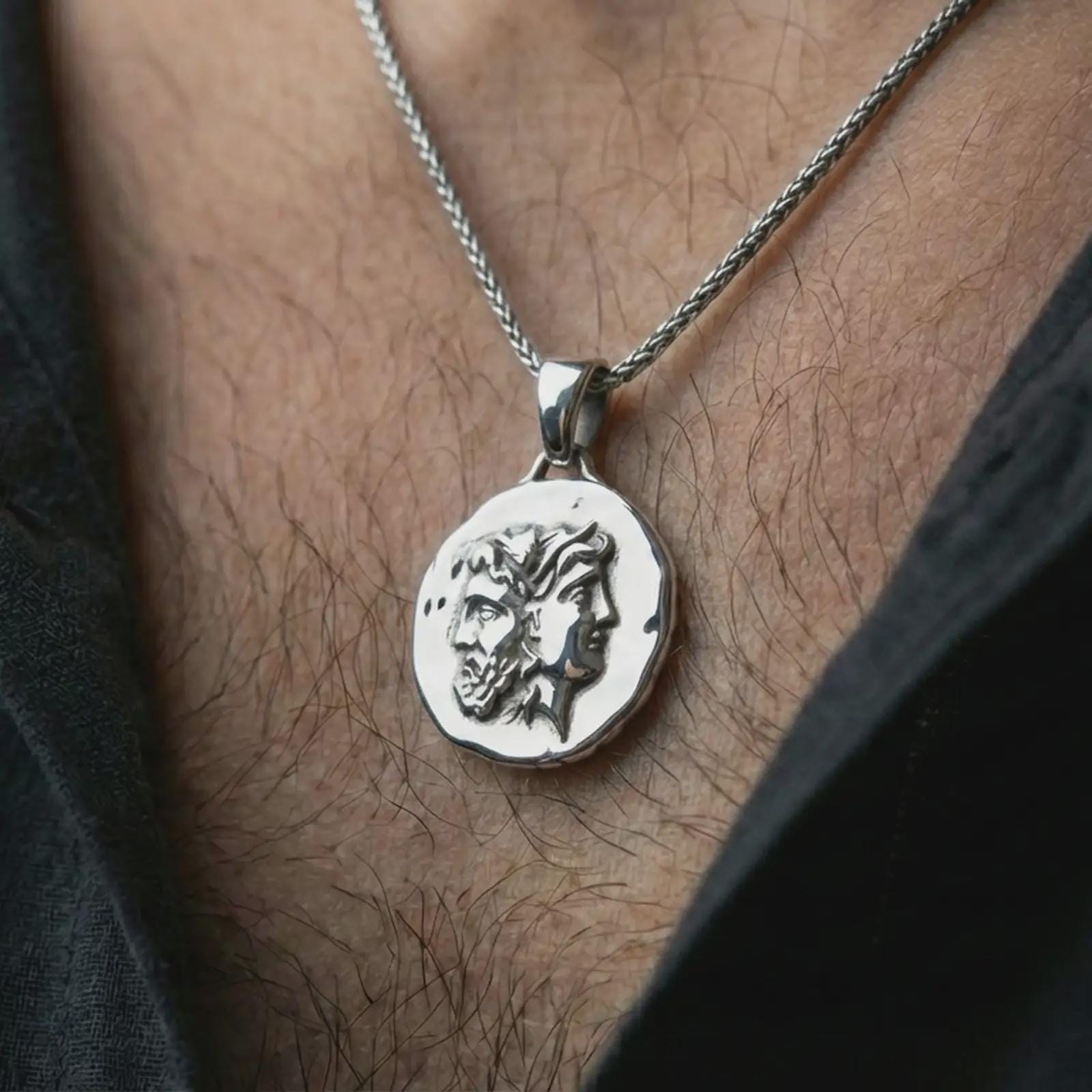 Polished silver Janus coin pendant necklace worn on the neck, shown in a clean model shot with the classical two-faced medallion centered for a refined antiquity-inspired look.