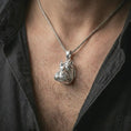 Load image into Gallery viewer, Polished silver hippo head pendant necklace worn on the chest, masculine lifestyle shot highlighting the sculpted hippopotamus face and bright silver finish.
