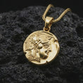 Load image into Gallery viewer, Gold plated Athena owl coin pendant necklace photographed on porous black volcanic stone, emphasizing the classical Greek owl design and historic medallion silhouette in a luxury jewelry composition.
