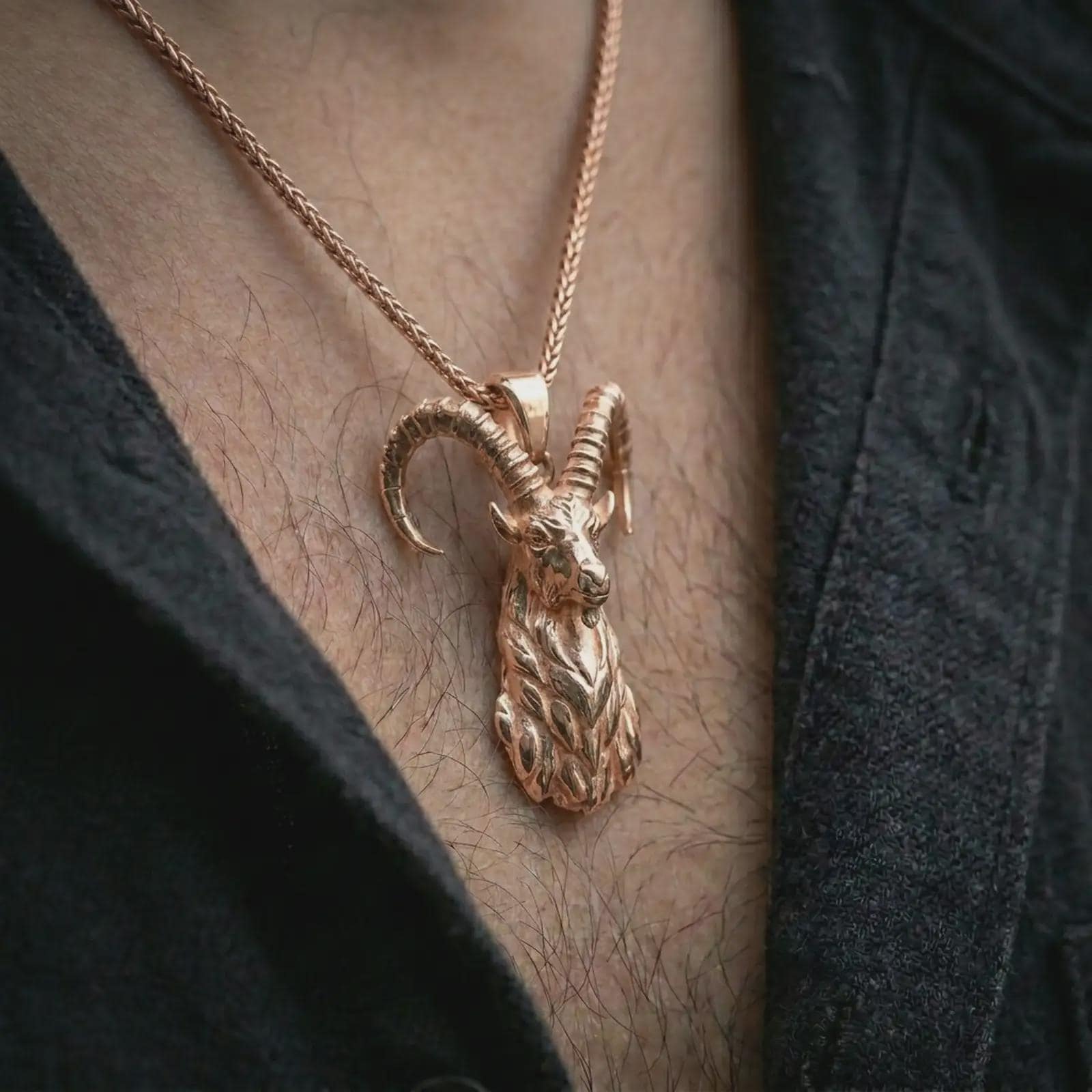 Rose gold plated ram horn pendant necklace worn on the chest, close-up lifestyle shot featuring the rustic ram horn design with warm rose gold tones.
