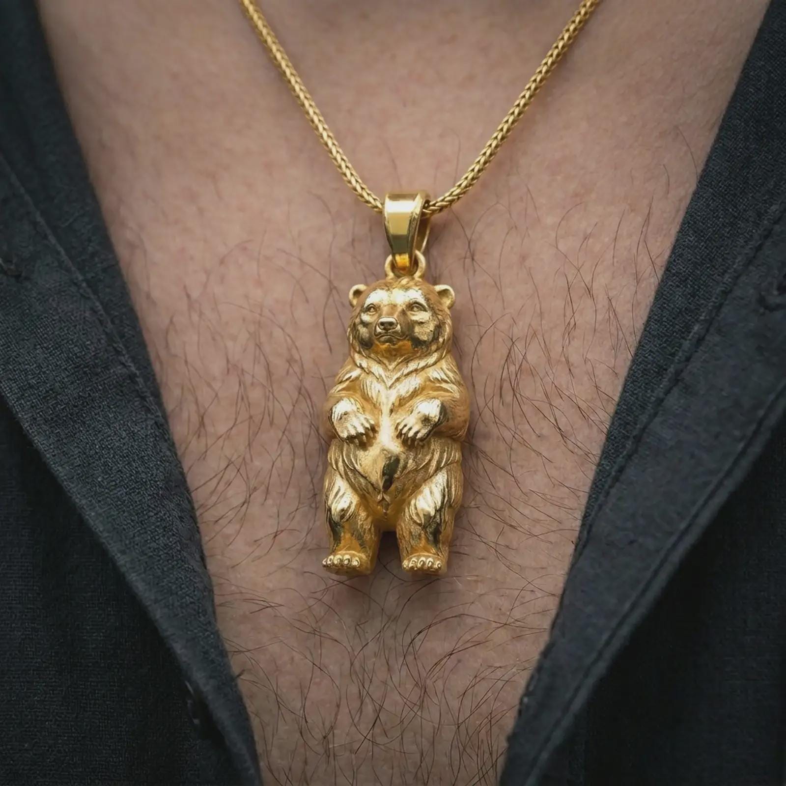 Gold plated baby bear pendant necklace worn on the chest, premium lifestyle jewelry photo with the cute bear cub pendant centered on a spiga chain.