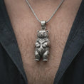 Load image into Gallery viewer, Oxidized baby bear pendant necklace worn on the chest, close-up lifestyle jewelry photo showing the bear cub charm on a spiga chain with dark clothing.
