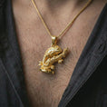 Load image into Gallery viewer, Gold plated chameleon pendant necklace worn on the chest, premium lifestyle jewelry photo with the chameleon branch pendant centered on a spiga chain.
