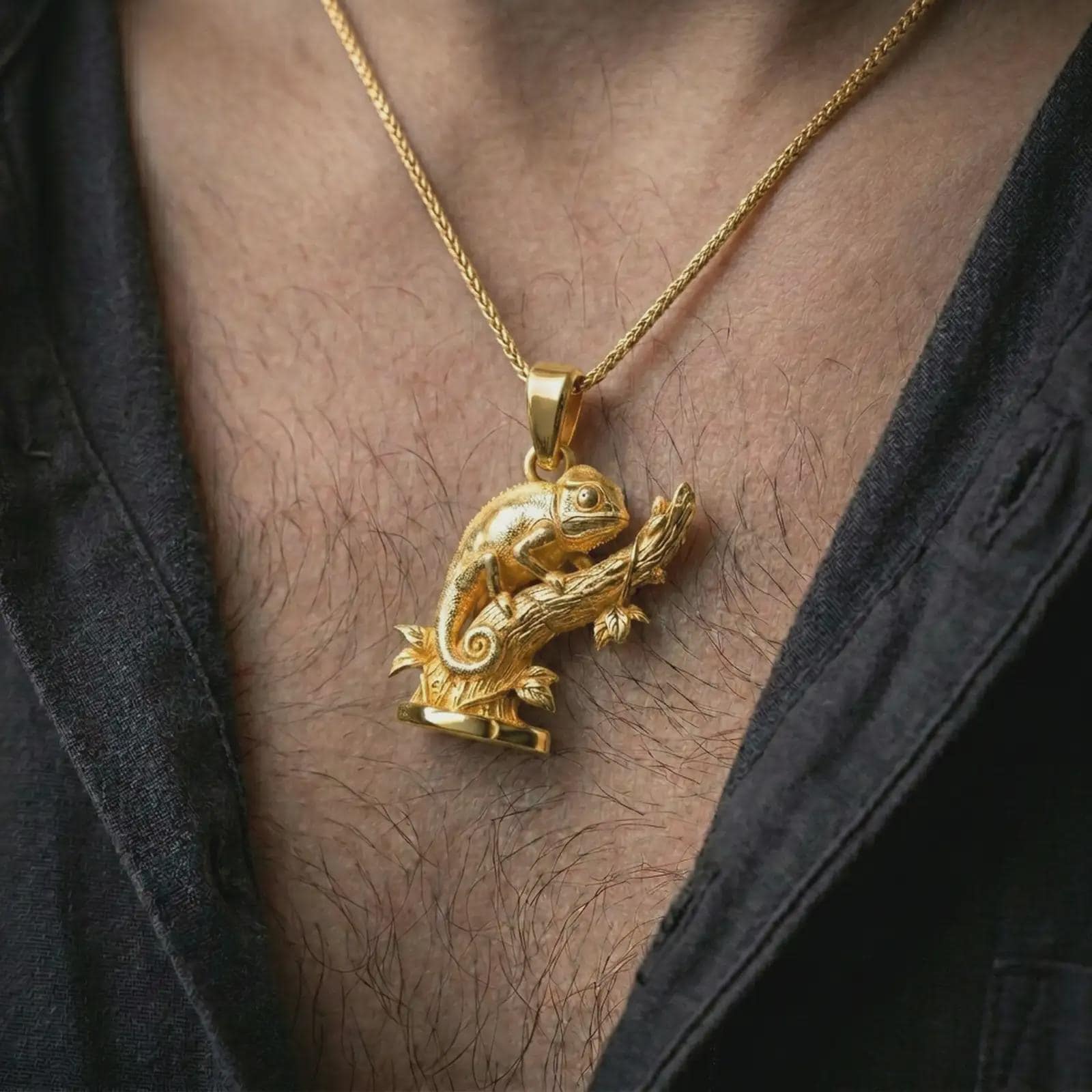 Gold plated chameleon pendant necklace worn on the chest, premium lifestyle jewelry photo with the chameleon branch pendant centered on a spiga chain.