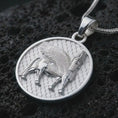 Load image into Gallery viewer, Polished silver Assyrian Lamassu pendant necklace on textured volcanic rock, centered macro jewelry photo with detailed Mesopotamian guardian spirit relief and bright silver highlights.
