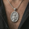 Load image into Gallery viewer, Polished silver Saint Joan of Arc pendant necklace worn on the chest, masculine lifestyle shot highlighting the armored saint relief, halo, and bright silver finish.
