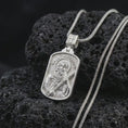 Load image into Gallery viewer, Polished silver Saint Andrew dog tag pendant necklace on textured volcanic rock, centered macro jewelry photo with detailed Catholic medal engraving and bright silver highlights.
