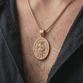 Load image into Gallery viewer, Rose gold plated Saint Roch pendant necklace worn on the chest, close-up lifestyle shot featuring the sacred Saint Roch design with warm rose gold tones.
