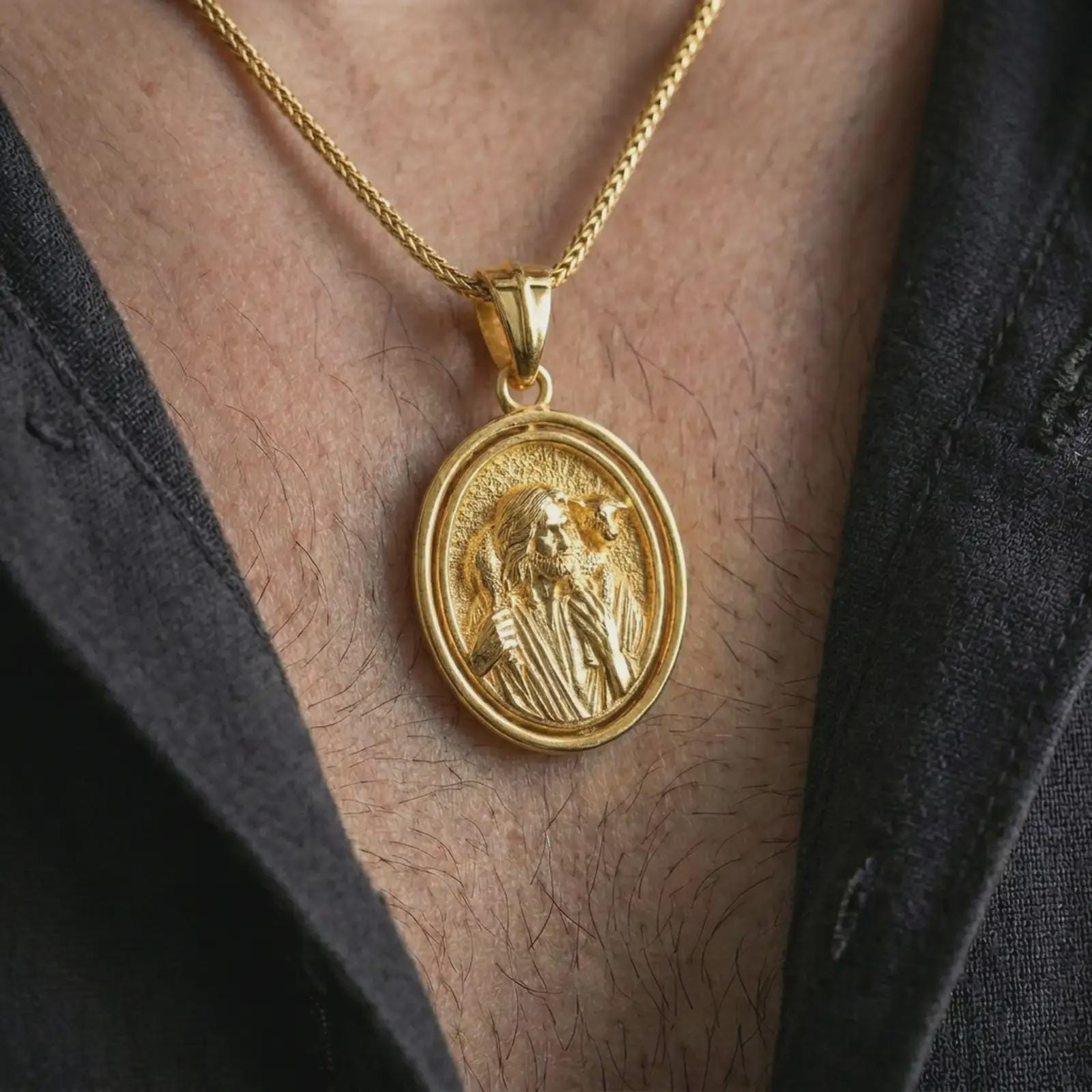 Gold plated spinning Good Shepherd pendant necklace worn on the chest, premium lifestyle jewelry photo with the rotating Good Shepherd medal centered on a spiga chain.
