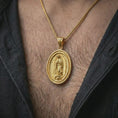 Load image into Gallery viewer, Gold plated Our Lady of Guadalupe spinner pendant necklace worn on the chest, premium lifestyle jewelry photo with the Marian spinner medal centered on a spiga chain.
