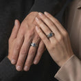 Load image into Gallery viewer, A sterling silver ring with an oxidized finish and marquise blue stone worn on a finger in a clean lifestyle close-up.
