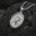 Load image into Gallery viewer, Polished silver spinning Jesus Christ pendant necklace on textured volcanic rock, centered macro jewelry photo with detailed Christian portrait relief and bright silver highlights.
