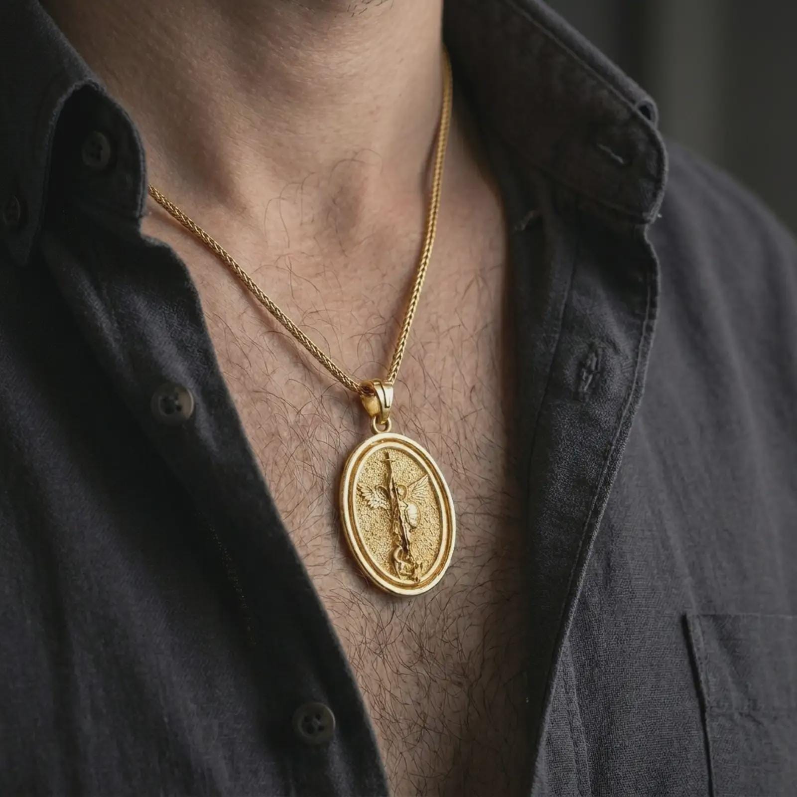 Gold plated Saint Michael spinning pendant necklace worn on the chest, premium lifestyle jewelry photo with the rotating Saint Michael medal centered on a spiga chain.