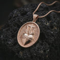 Load image into Gallery viewer, Rose gold plated Sacred Heart pendant necklace on textured volcanic rock, detailed macro product shot with soft warm reflections and devotional Sacred Heart design.
