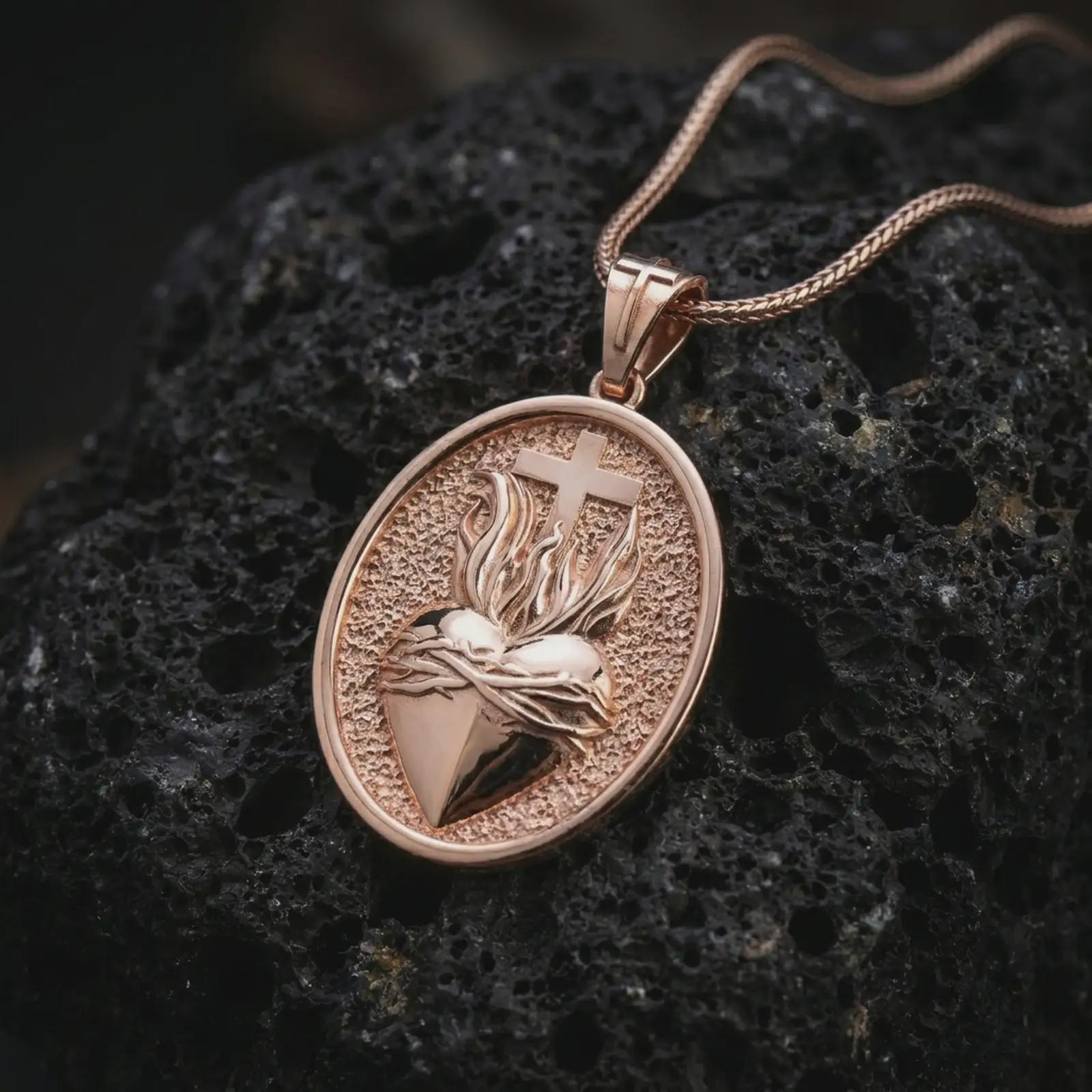 Rose gold plated Sacred Heart pendant necklace on textured volcanic rock, detailed macro product shot with soft warm reflections and devotional Sacred Heart design.