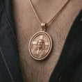 Load image into Gallery viewer, Rose gold plated spinning Jesus Christ pendant necklace worn on the chest, close-up lifestyle shot featuring the sacred Jesus Christ design with warm rose gold tones.
