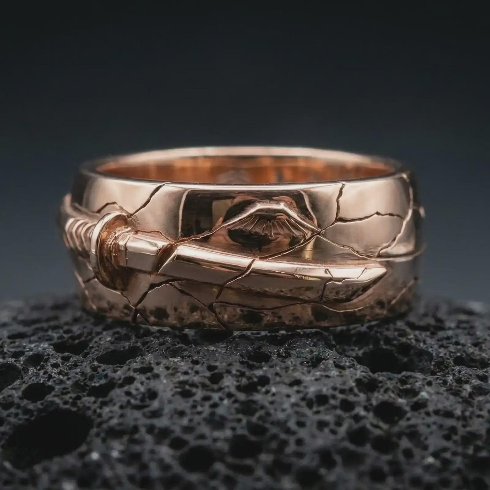 Rose gold plated Bushido sword band ring on textured volcanic rock, detailed macro product shot with soft warm reflections and Japanese warrior-inspired design.