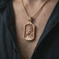 Load image into Gallery viewer, Rose gold plated INRI Jesus pendant necklace worn on the chest, close-up lifestyle shot featuring the sacred INRI Jesus design with warm rose gold tones.
