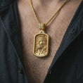 Load image into Gallery viewer, Gold plated INRI Jesus pendant necklace worn on the chest, premium lifestyle jewelry photo with the Jesus portrait medal centered on a spiga chain.
