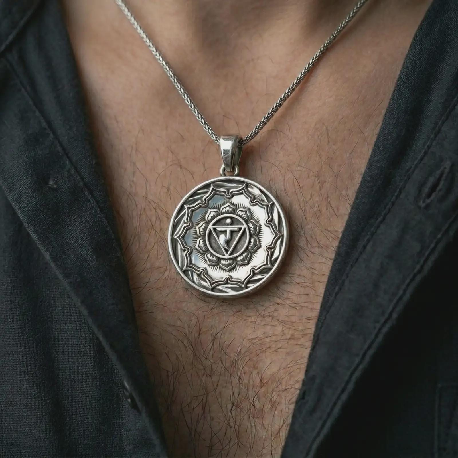 Polished silver Manipura chakra pendant necklace worn on the chest, masculine lifestyle shot highlighting the chakra symbol, lotus detail, and bright silver finish.