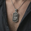 Load image into Gallery viewer, Oxidized Jesus prayer dog tag pendant necklace worn on the chest, close-up lifestyle jewelry photo showing the Christian medallion on a spiga chain with dark clothing.
