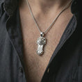 Load image into Gallery viewer, A polished silver Taurus bull pendant is worn on the neck in a premium close-up lifestyle image, showing the horned animal motif clearly.
