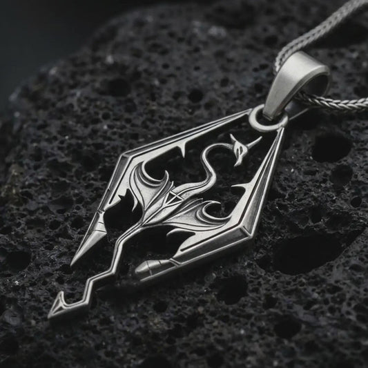 Oxidized Skyrim dragon pendant necklace on textured volcanic rock, close-up studio shot highlighting the angular dragon emblem, openwork design, and antique silver contrast.