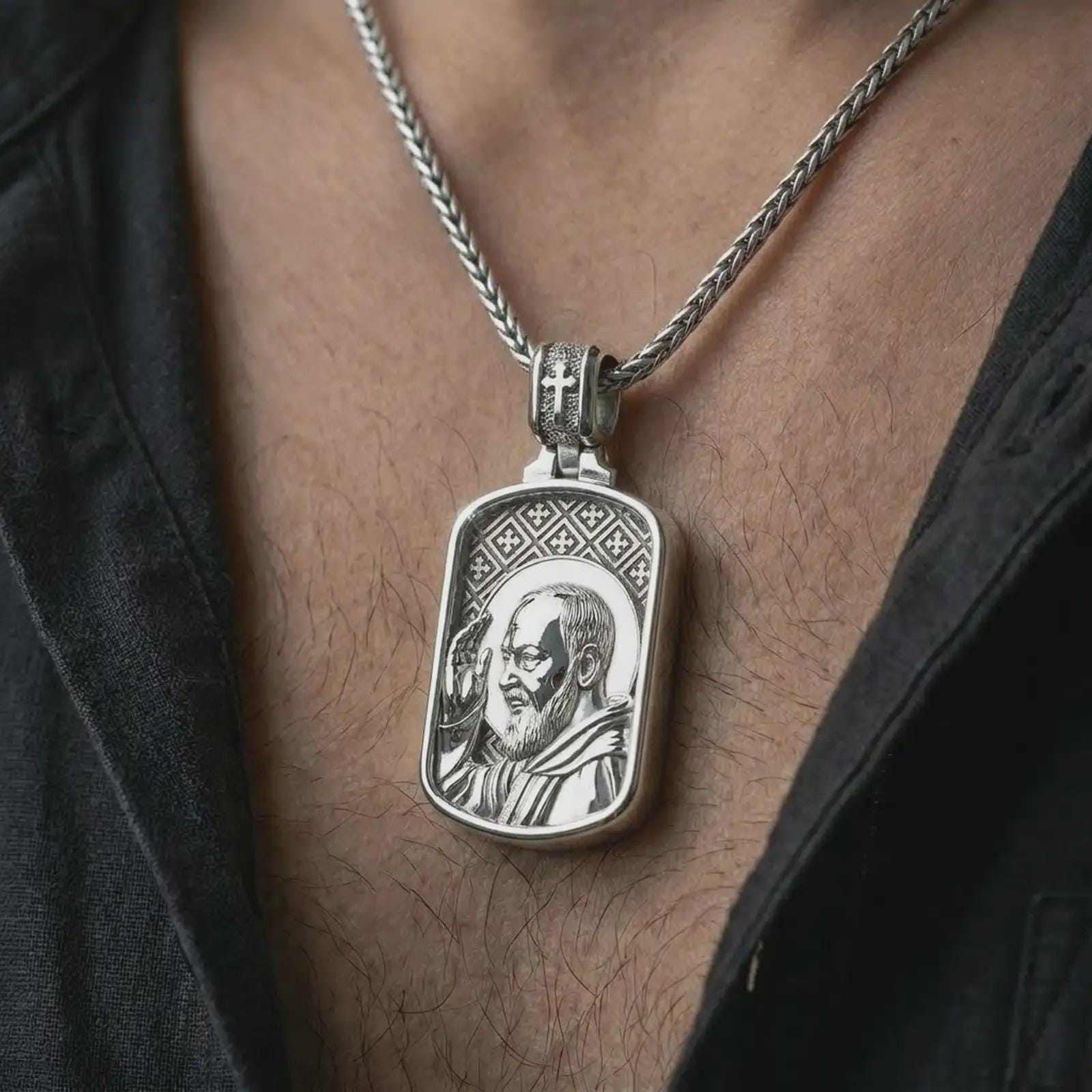 Polished silver Saint Padre Pio dog tag pendant necklace worn on the chest, masculine lifestyle shot highlighting the saint profile relief, blessing gesture, and bright silver finish.