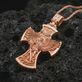 Load image into Gallery viewer, Rose gold plated Saint Michael cross pendant necklace on textured volcanic rock, detailed macro product shot with soft warm reflections and protective archangel design.
