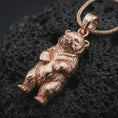 Load image into Gallery viewer, Rose gold plated baby bear pendant necklace on textured volcanic rock, detailed macro product shot with soft warm reflections and sweet baby bear jewelry styling.
