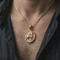 Load image into Gallery viewer, Rose gold plated Assyrian Lamassu pendant necklace worn on the chest, close-up lifestyle shot featuring the ancient Lamassu design with warm rose gold tones.
